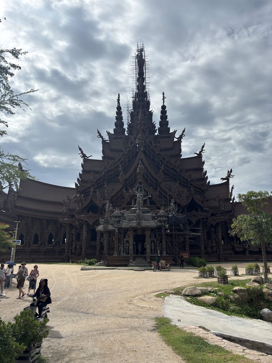 曇り空の下にそびえる木造寺院の全景。尖塔が幾重にも重なる