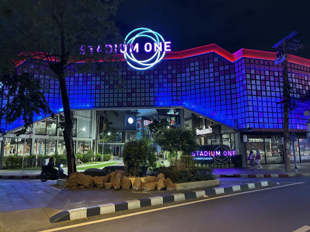 青と紫にライトアップされたガラス張りの建物。「STADIUM ONE」の看板