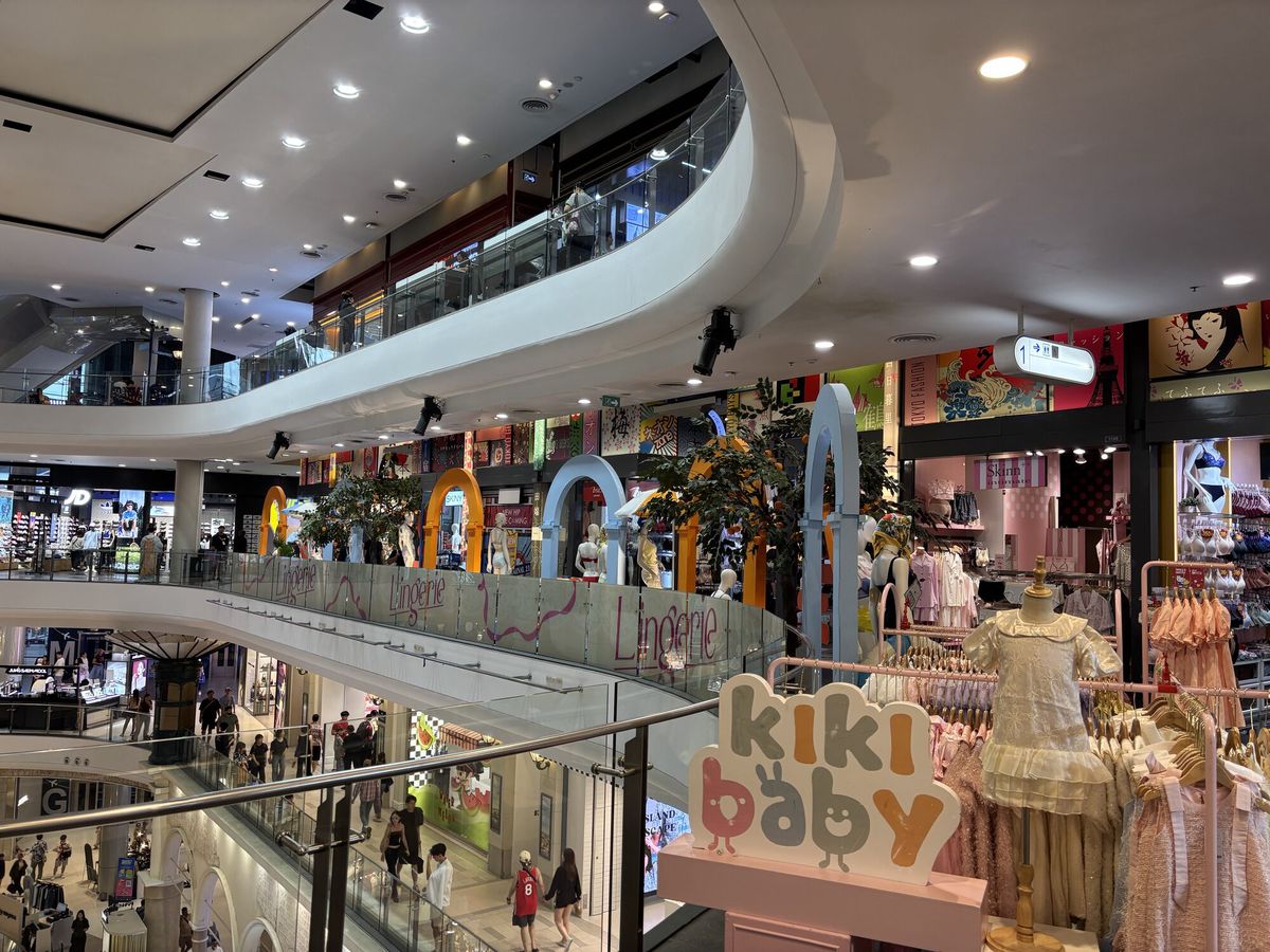吹き抜けのショッピングモール。曲線の手すりに沿って店が並ぶ